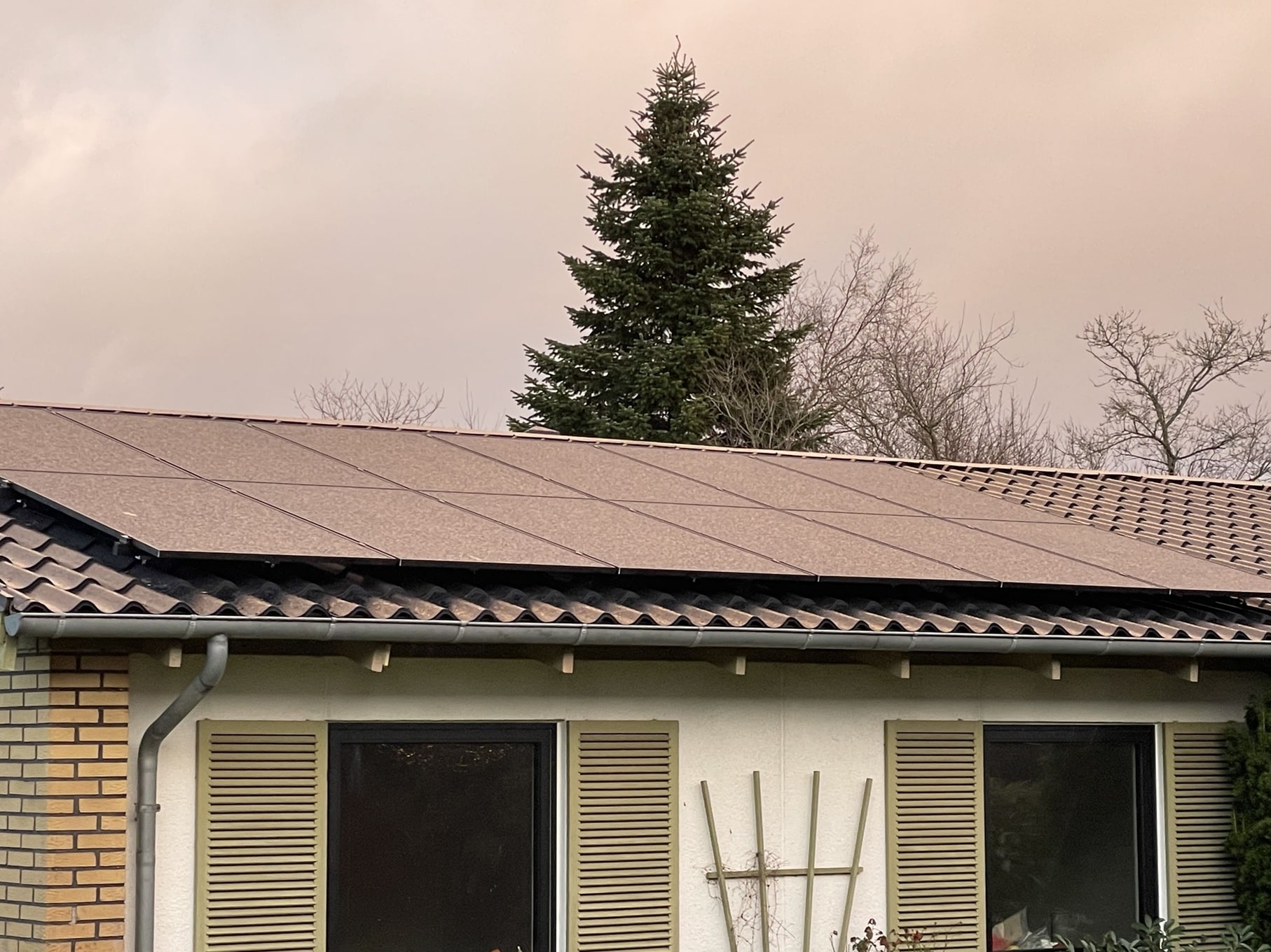 Solcellepaneler på tag med blå himmel i baggrunden